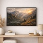 Framed mountain landscape print with scripture on a wall above a wooden console table.