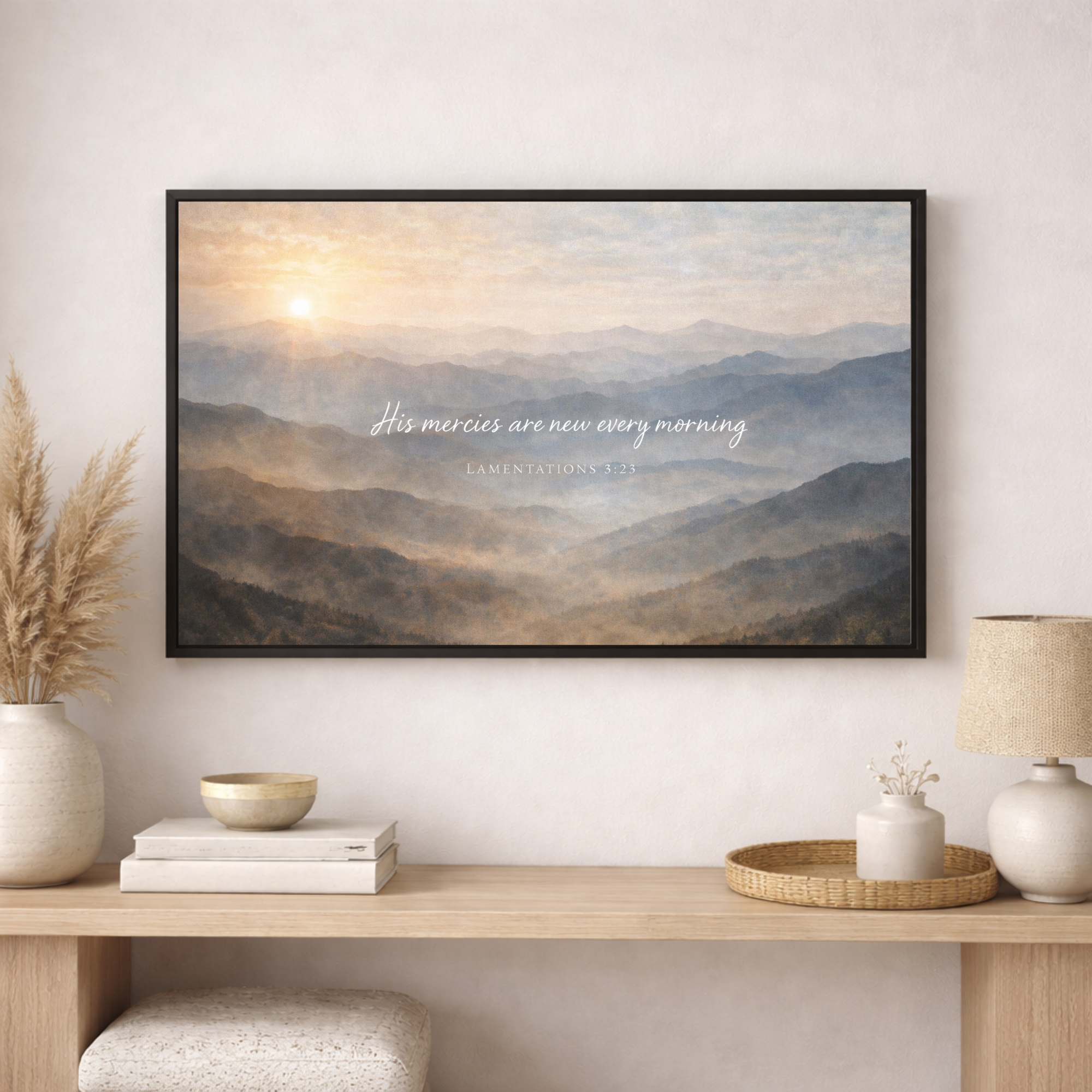 Framed mountain landscape print with text on a wall above a wooden console table.