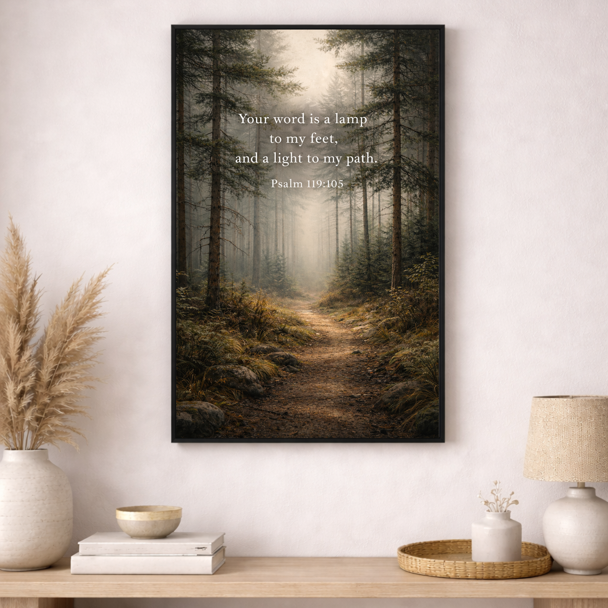 Framed artwork of a forest path with a quote on a wall above a wooden table.
