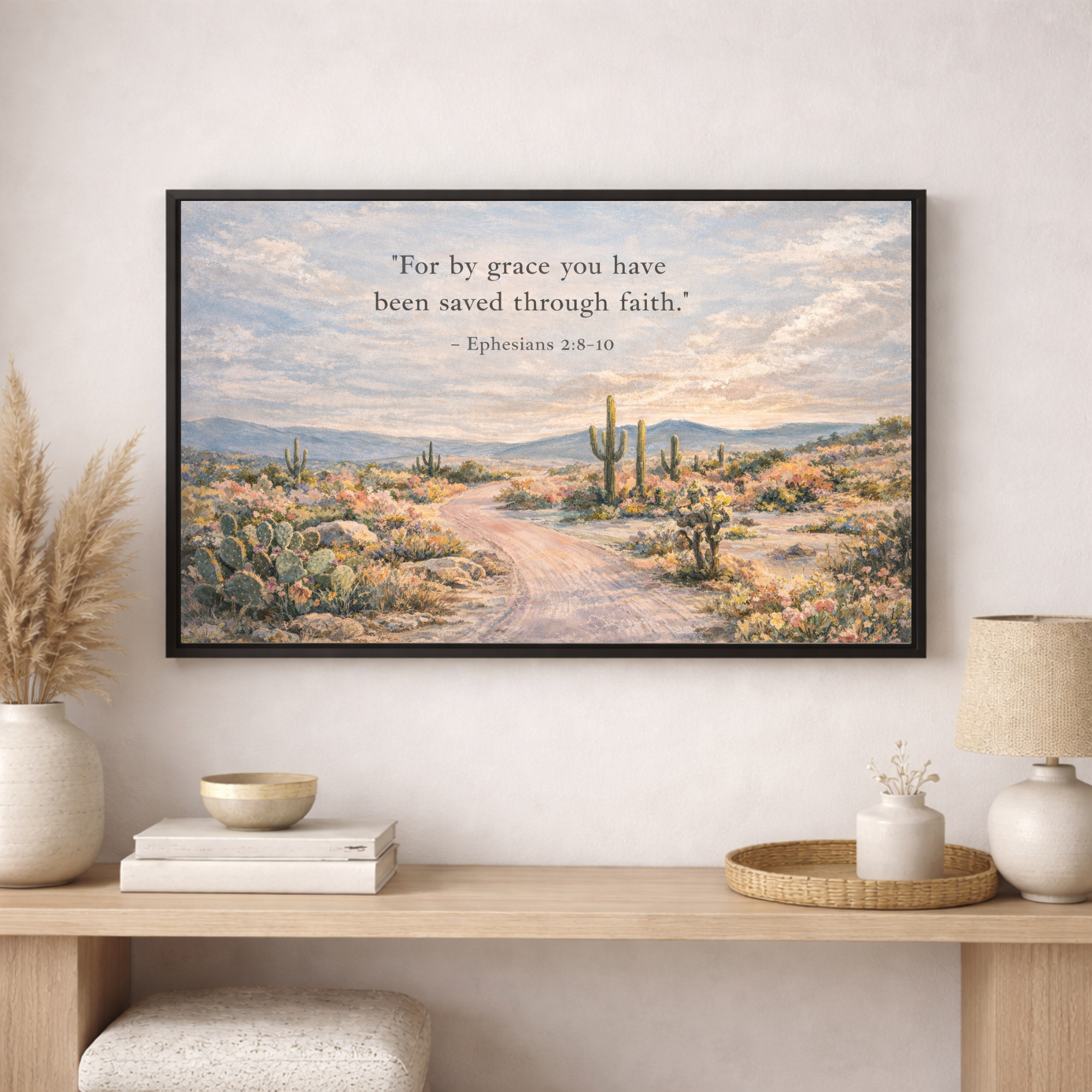 Framed desert landscape print with a quote on a wall above a wooden console table.