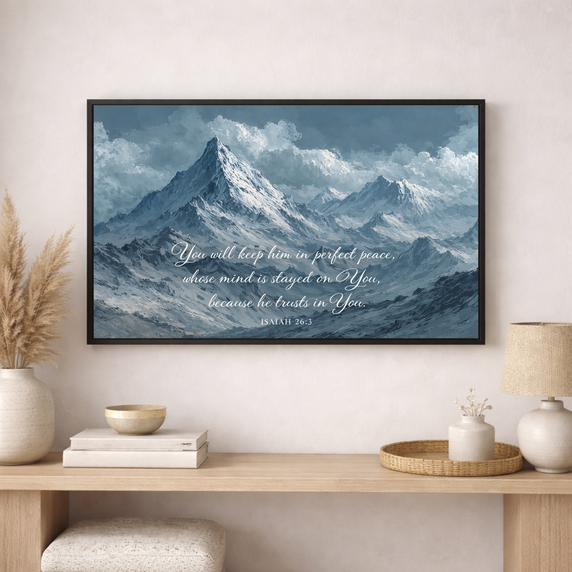 Framed mountain landscape print with a quote on a wall above a wooden console table.