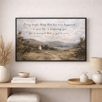 Framed landscape print with motivational quote on a wall above a wooden console table.