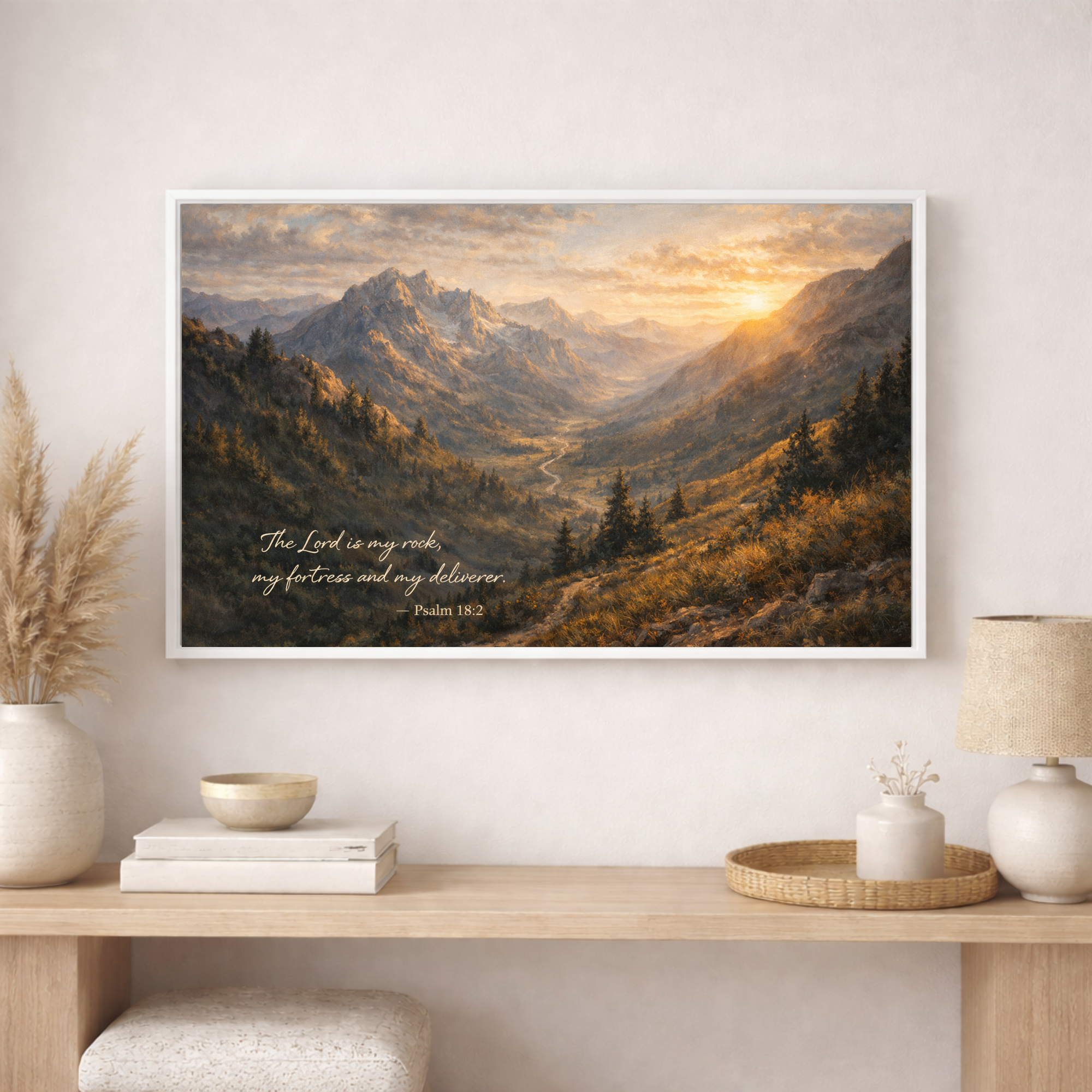 Framed mountain landscape print with scripture on a wall above a wooden console table.