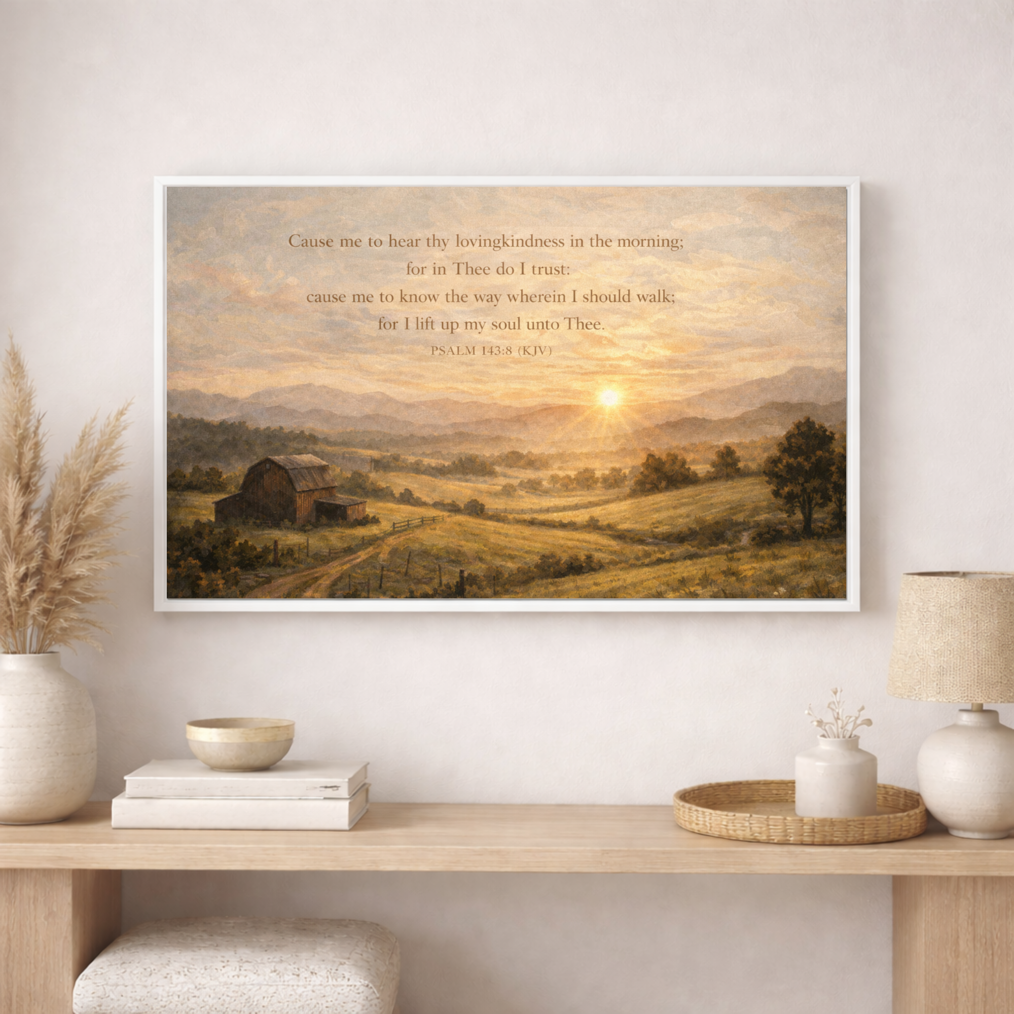 Framed landscape print with a sunset over a field on a wall above a wooden console table.