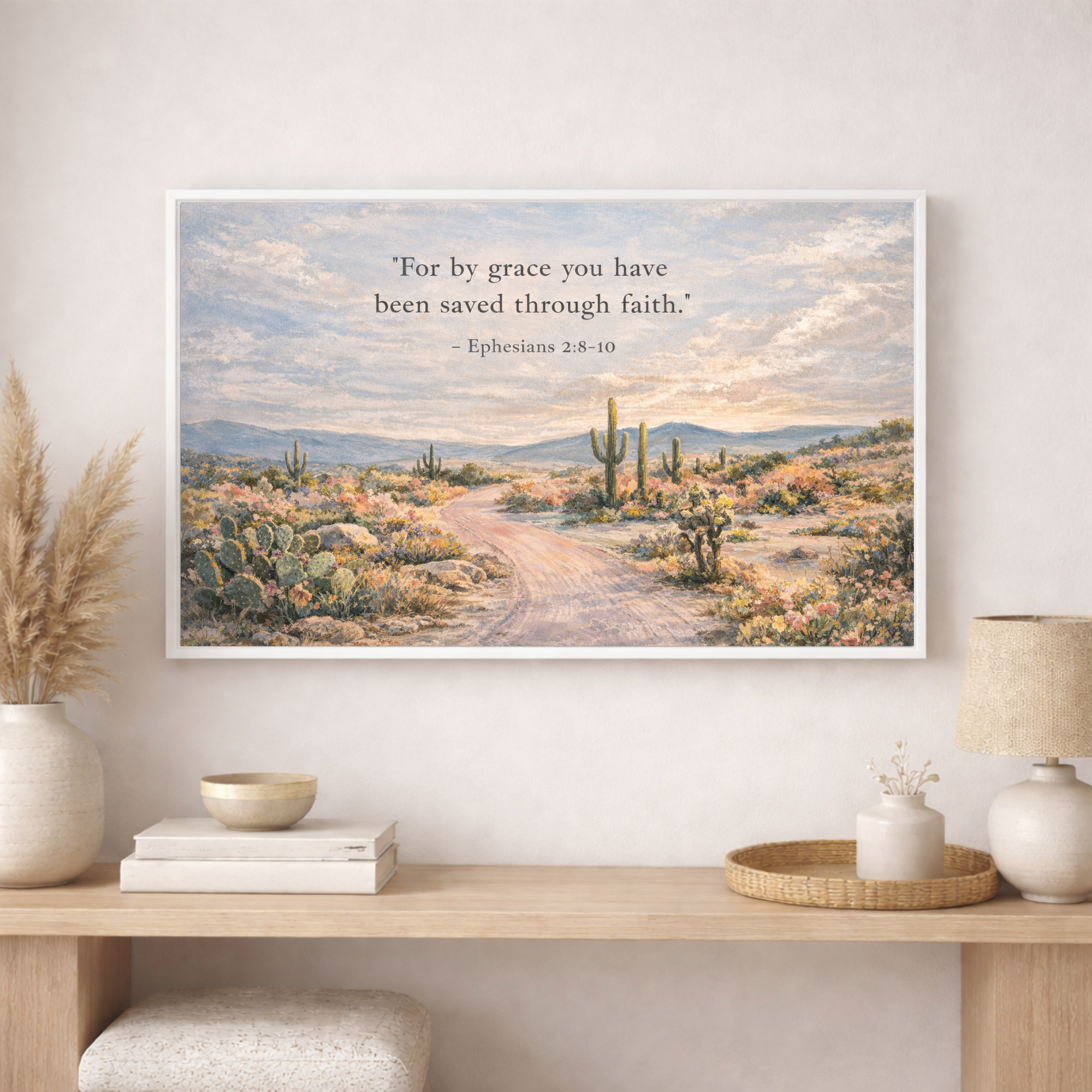 Framed desert landscape print with scripture on a wall above a wooden shelf.