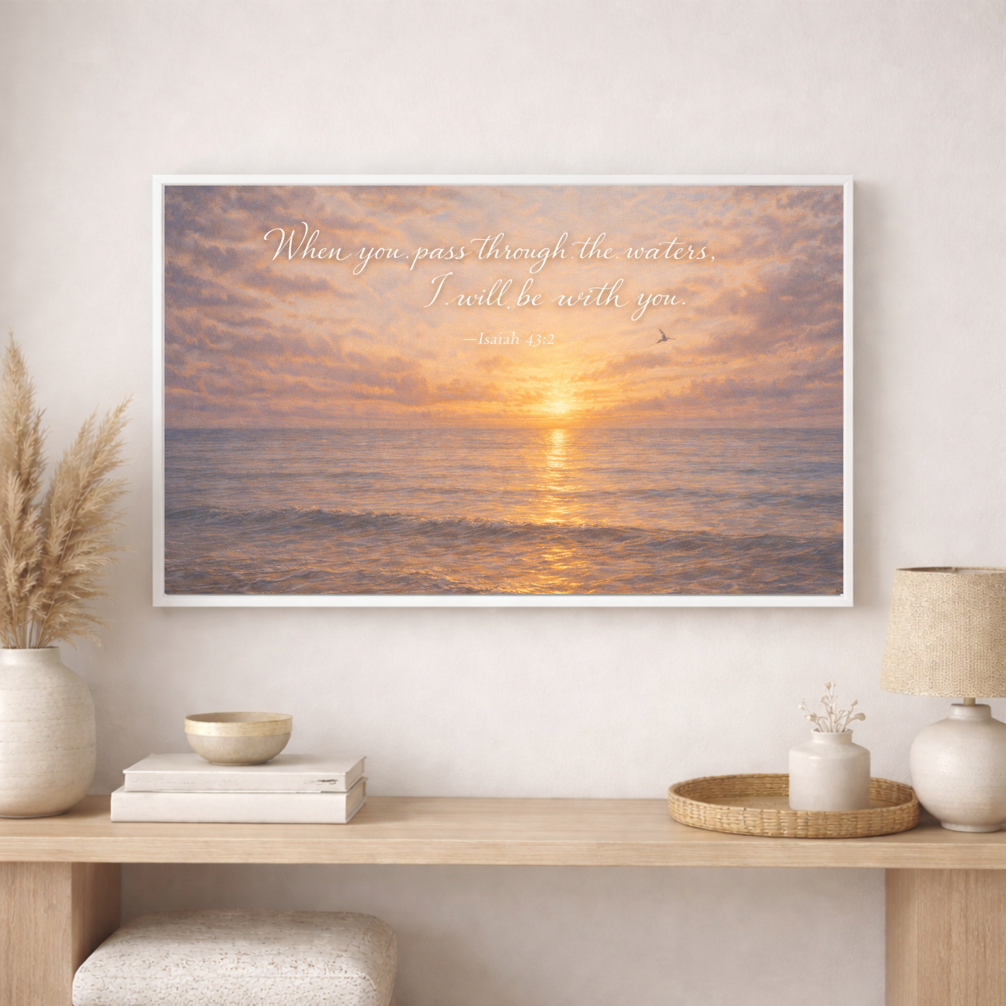 Framed artwork with sunset over water and text above a wooden console table.